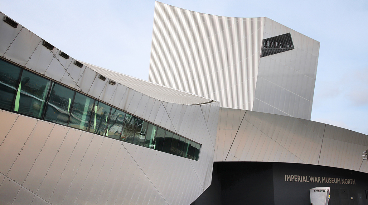 Een driedelige structuur van grijs staal in geometrische vormen, met de tekst ‘Imperial War Museum North’